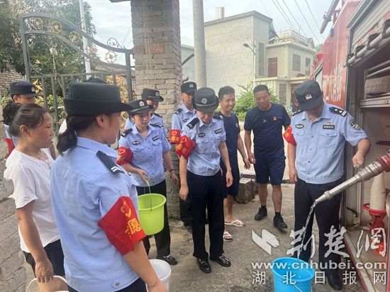 民輔警跟隨消防水車作業(yè)，通過肩挑手提的方式將清水送入行動不便的老年、殘障村民的家中（通訊員 李麗君 攝） (3).jpg.jpg
